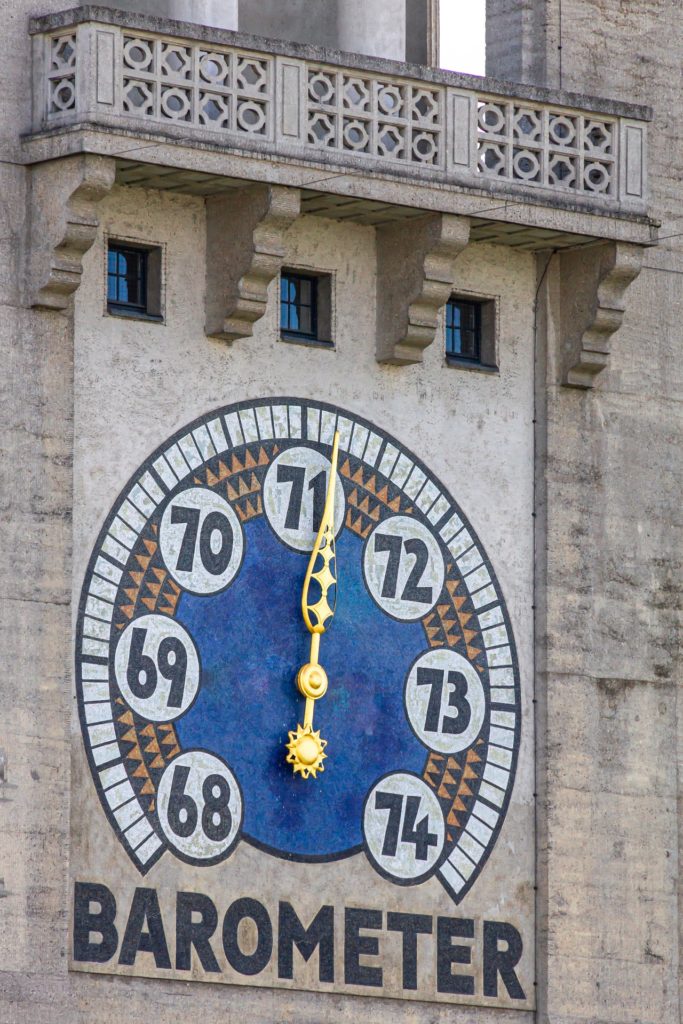 Ein Großes Barometer an einer Gebäudewand.